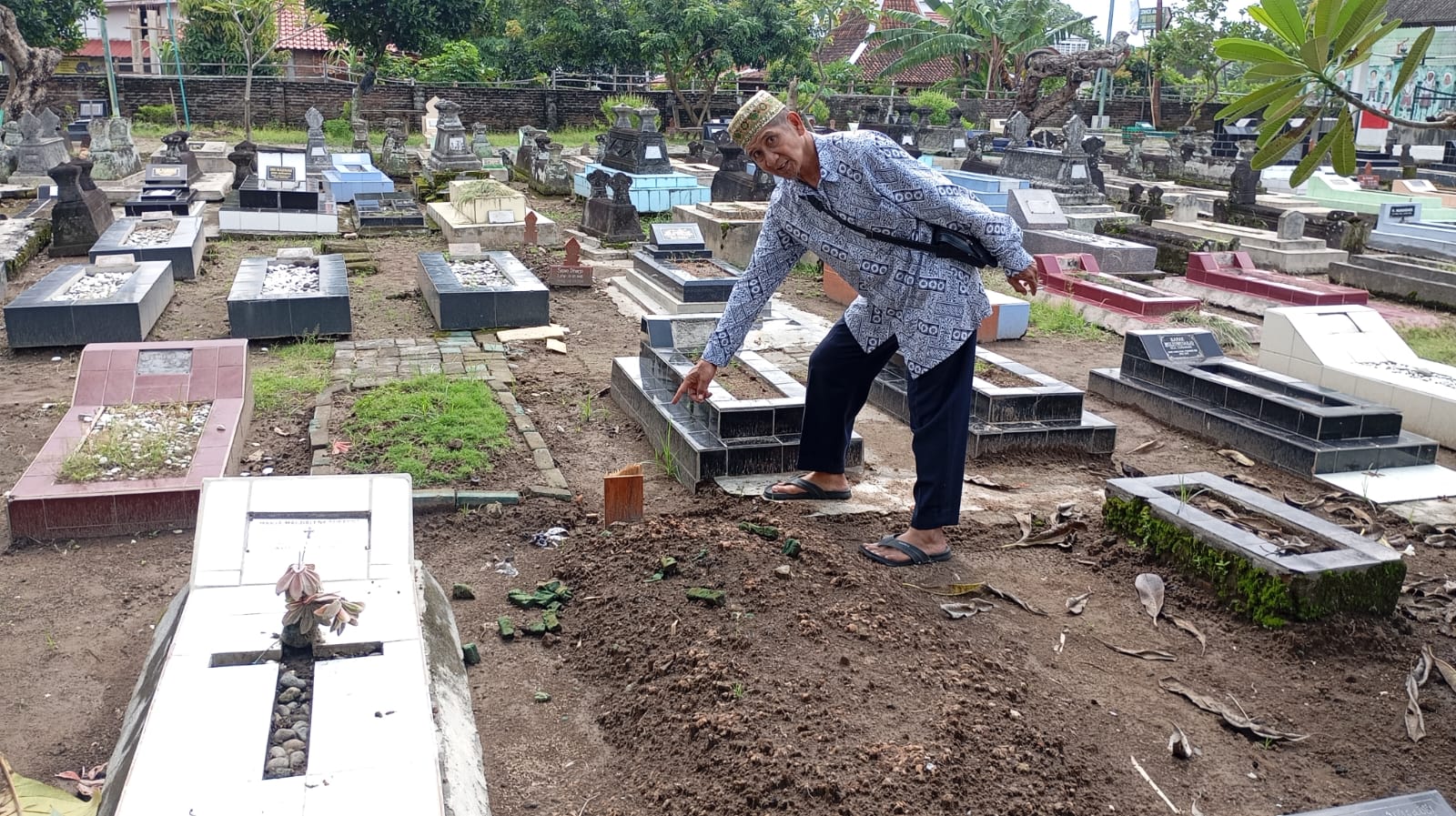 RUSAK: Ketua RW 04 Kampung Basen, Purbayan, Kotagede Wahyono menunjukkan makam yang dirusak orang tidak dikenal pada Senin (19/5/2025).