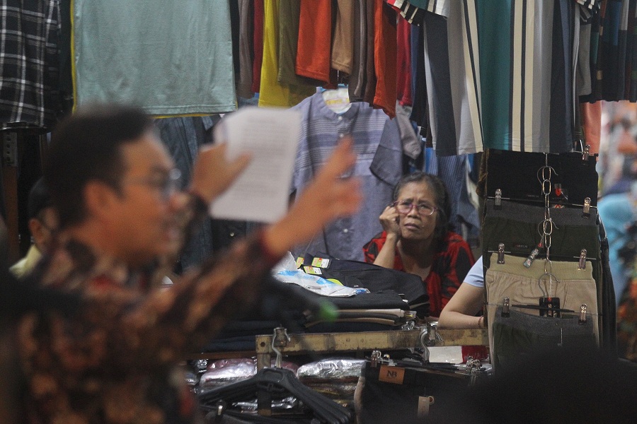 Seorang pedagang busana menyimak sambutan Wali Kota Jogja Hasto Wardoyo (kiri) saat acara peluncuran Beringharjo Official Store, di Pasar Beringharjo, Kota Jogja, Kamis (22/5/2025).