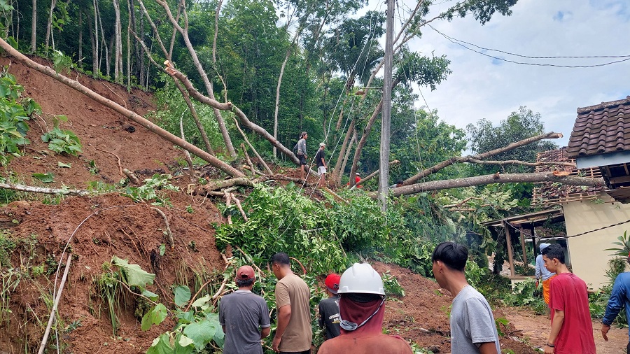 KERJA BAKTI: Warga bergotong royong membersihkan material longsor yang berdampak ke rumah warga.