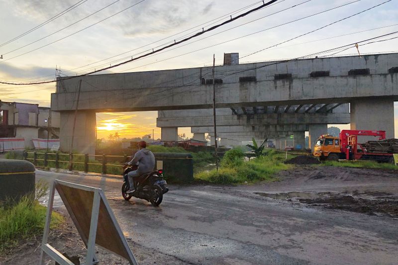 Pengguna jalan melintas di dekat proyek jalan Tol Jogja-Bawen, di wilayah Margokaton, Kapanewon Seyegan, Sleman, Jumat (23/5).