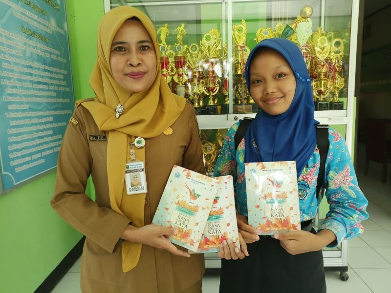 HASIL KARYA: Kepala SMPN 1 Buluspesantren Tri Nurhayati bersama Pristi Annisa Cahya Sukmaningrum menunjukkan buku berisi kumpulan sastra karya siswa.