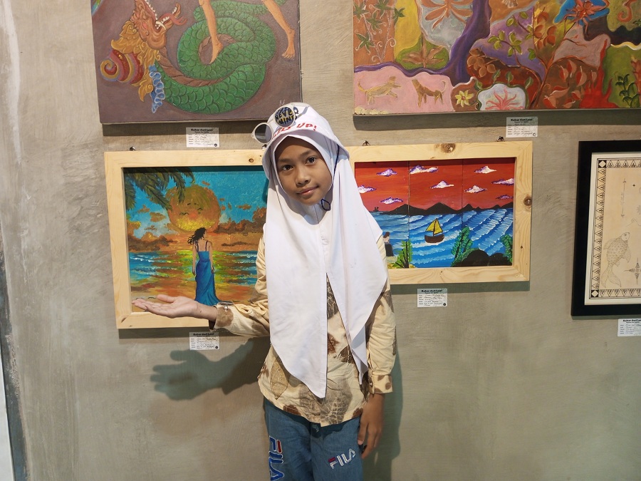 UNJUK DIRI: Gretta sedang menunjukkan dua karyanya dalam pameran seni rupa Kabar Dari Laut, Kamis (29/5/2025).