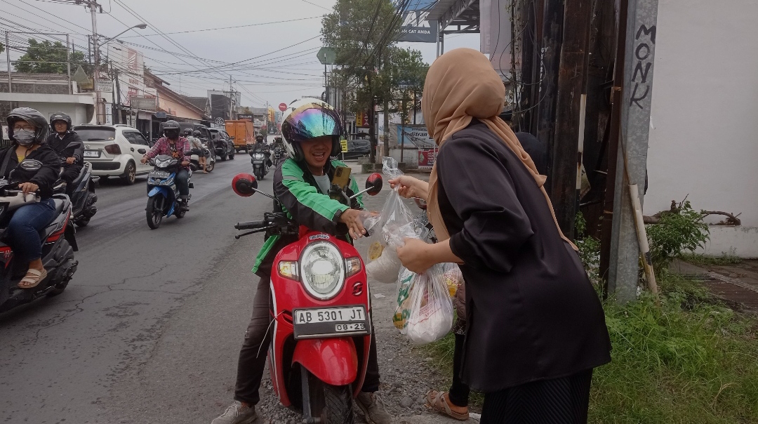 Direktur Andalan Money Changer Ir. Intan Pranandari, membagikan paket sembako kepada pengguna Jalan Godean
