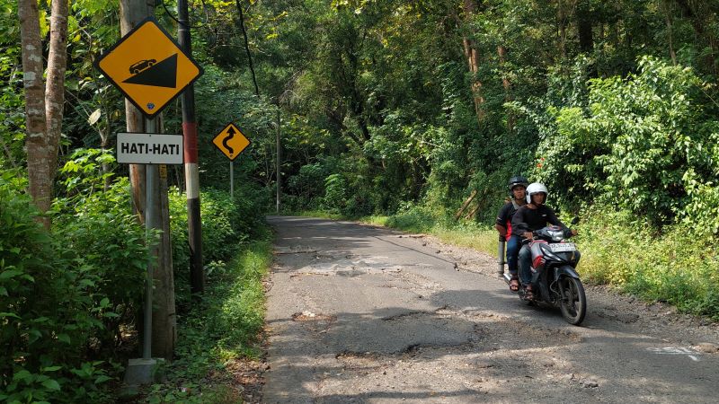 MELIPIR: Kendaraan memelankan kecepatan saat melewati jalan berlubang di Waduk Sermo.&nbsp;