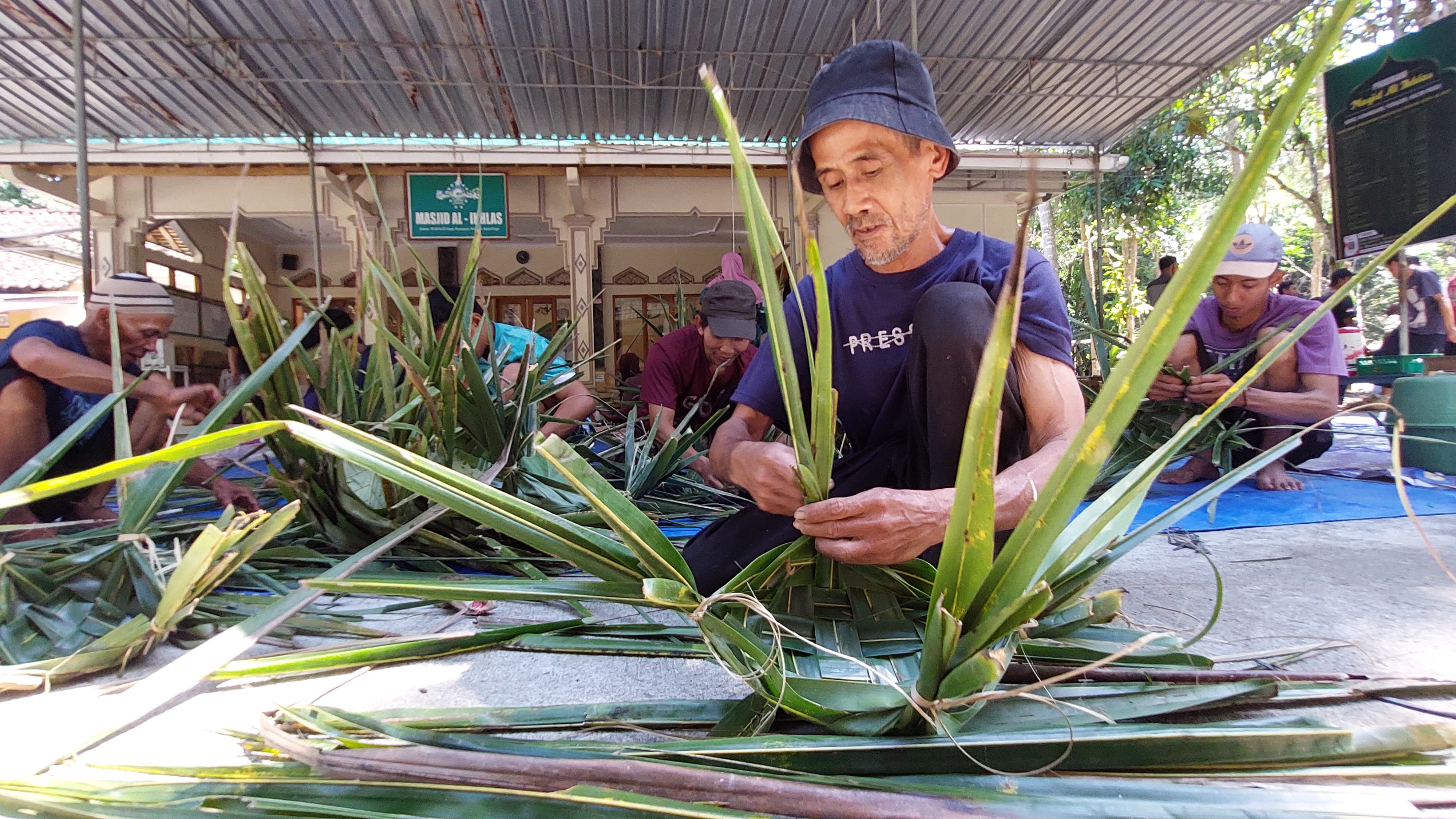 KREATIF SEKALIGUS RAMAH LINGKUNGAN: Warga Padukuhan Kopat, Kulon Progo ini memanfaatkan potensi pohon kelapa dengan menyulap daun kelapa menjadi  wadah untuk daging kurban, pengganti kantong plastik.