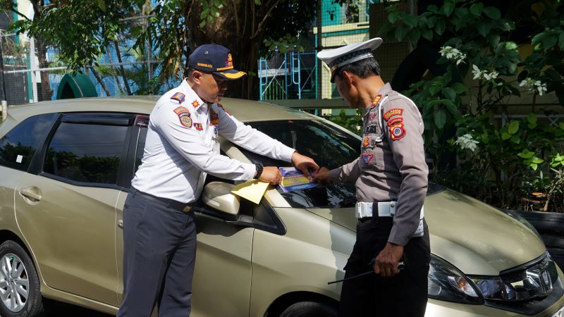 SALAHI ATURAN: Petugas saat menempelkan stiker peringatan bagi kendaraan yang melanggar ketentuan parkir di Jalan Kapas Rabu (11/6).