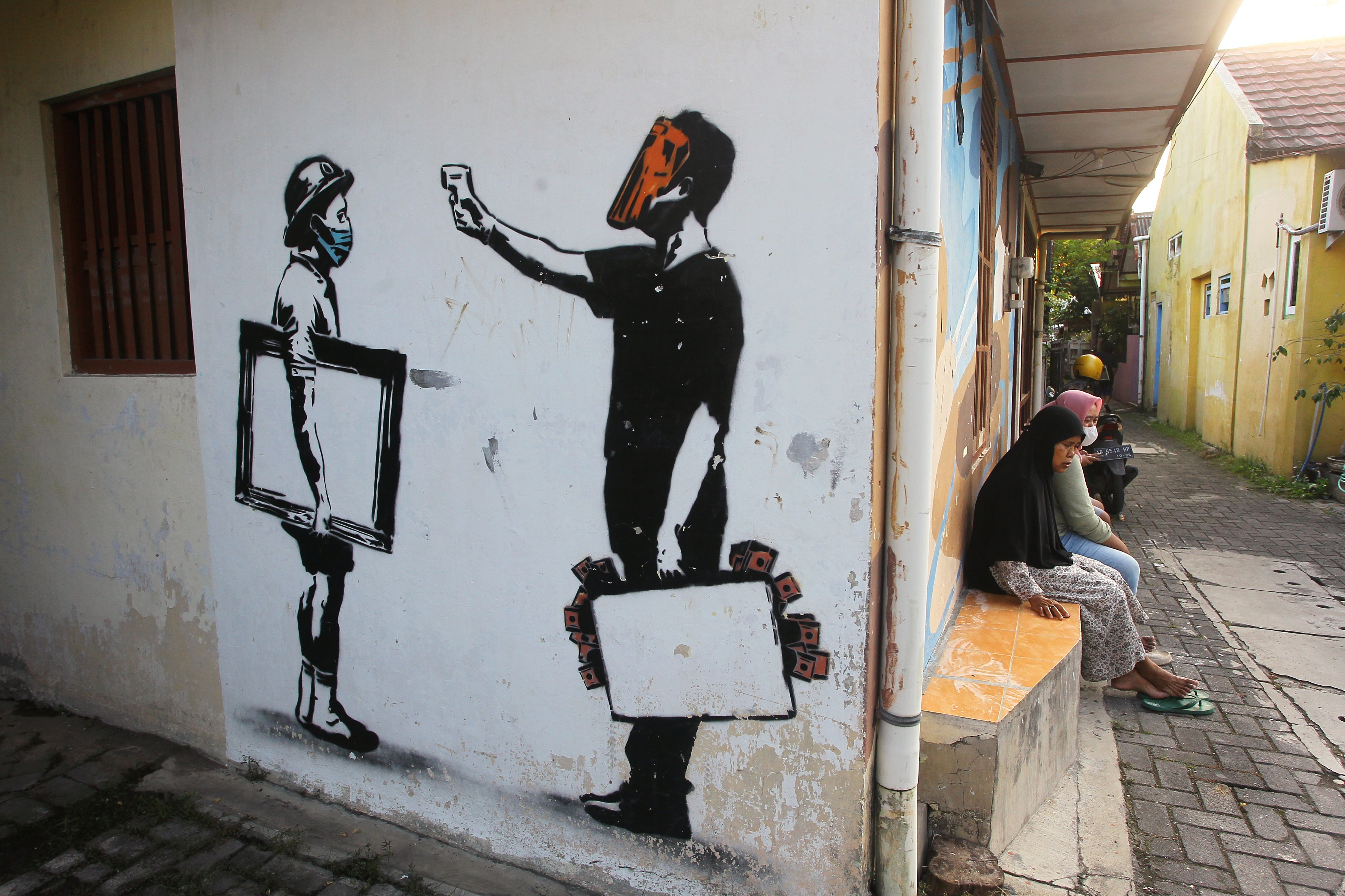 Warga bercengkerama di dekat mural bertema Covid-19 di Kampung Taman, Patehan, Kemantren Kraton, Kota Jogja, kemarin (11/6). Dinas Kesehatan Provinsi DIJ mencatat ada satu pasien positif Covid-19 pada