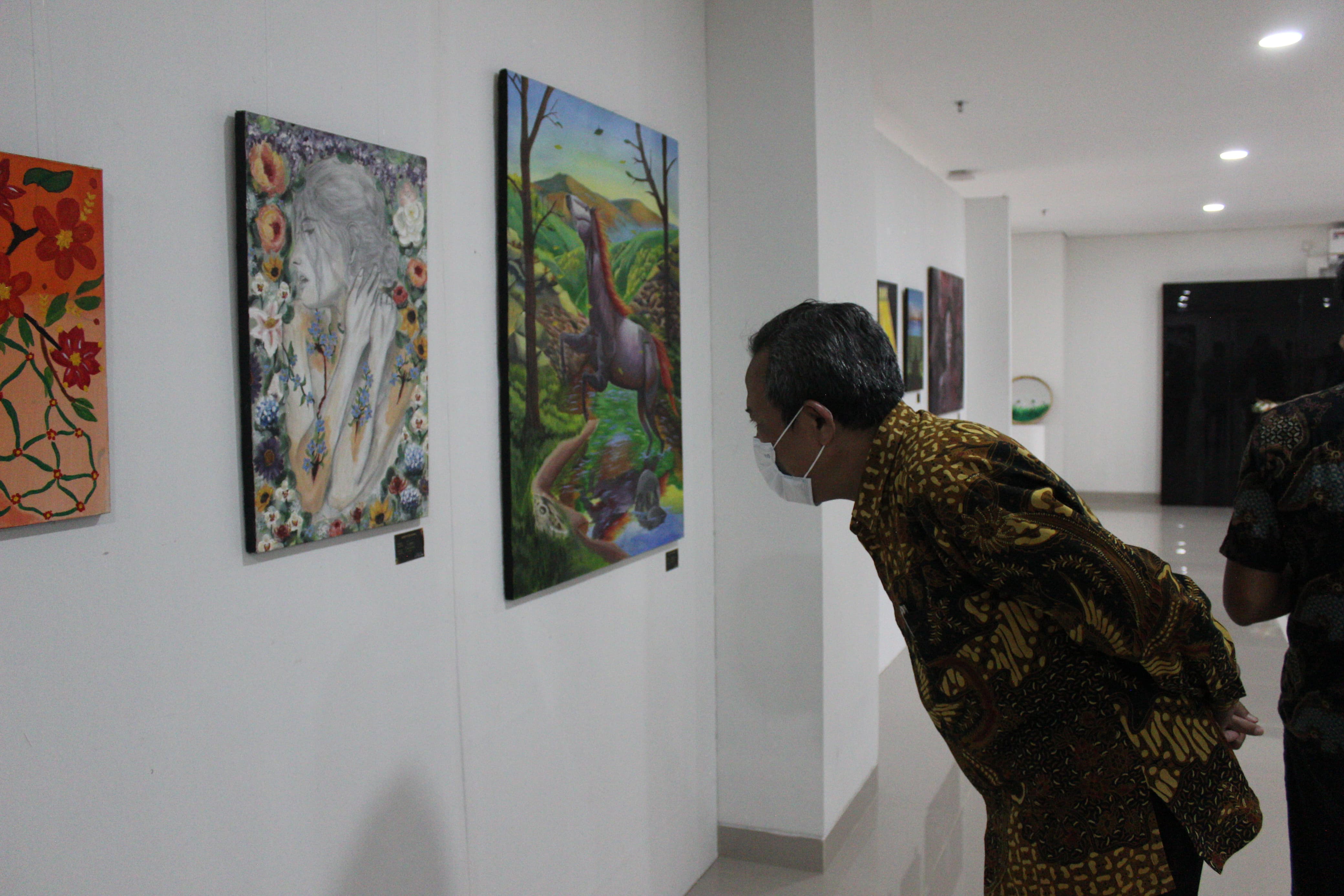 Salah seorang pengunjung mengamati karya di event DedicArt 2025 Padmanaba.