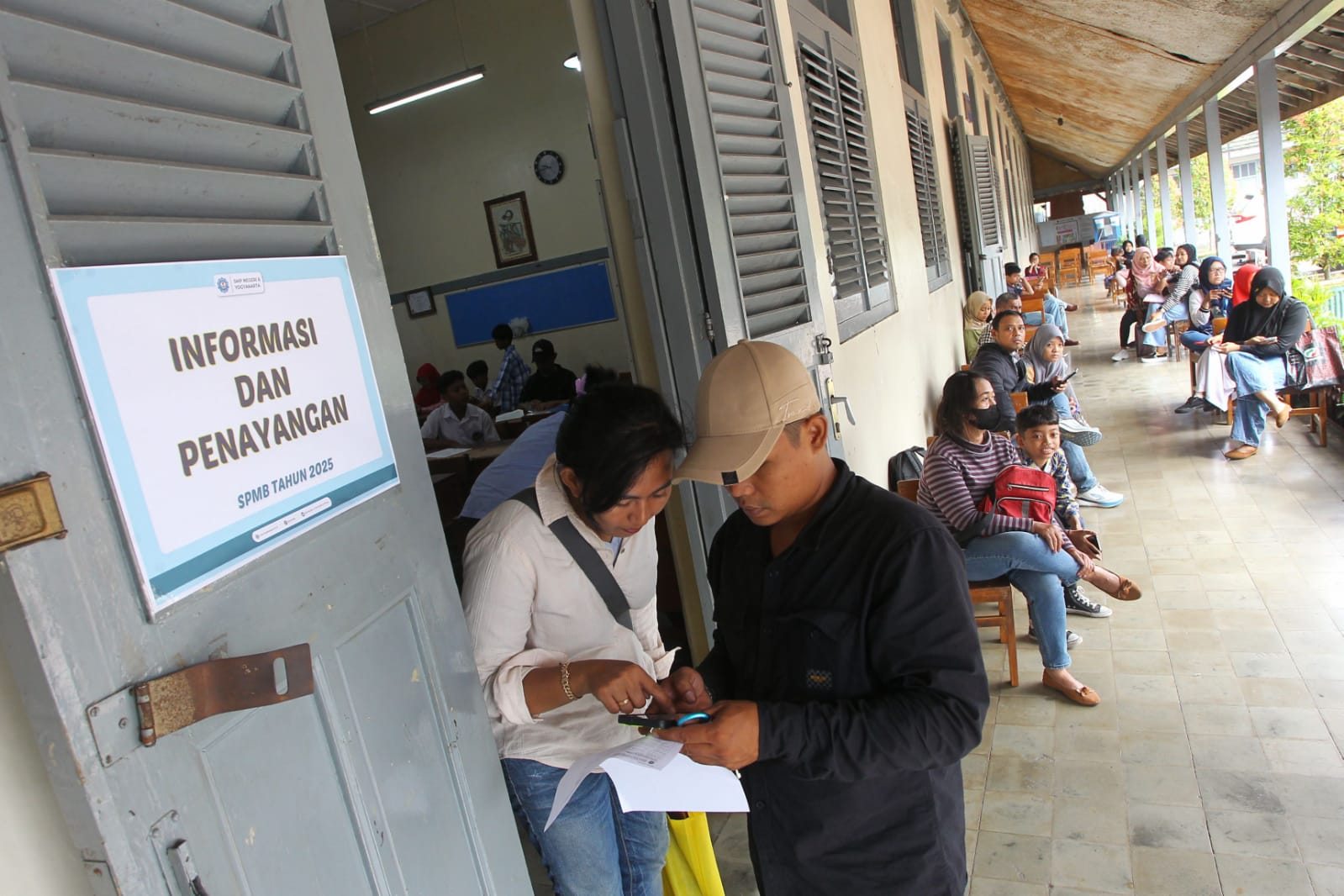 Orang tua calon murid baru mengurus tahapan verifikasi Sistem Penerimaan Murid Baru (SPMB) jalur domisili radius, di SMP Negeri 6 Kota Jogja, Jumat (20/6/2025).