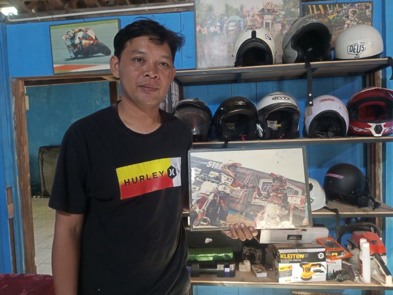 LATIHAN KERAS SEJAK KECIL: Sudarmono menunjukkan foto Veda Ega Pratama kecil usia 6 tahun saat balapan motor cross.