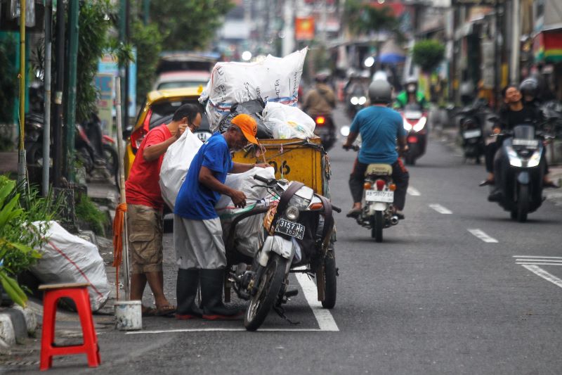 ATASI MASALAH: Transporter atau penggerobak saat mengambil sampah di kawasan Ngasem, Kota Jogja Senin (23/6).
