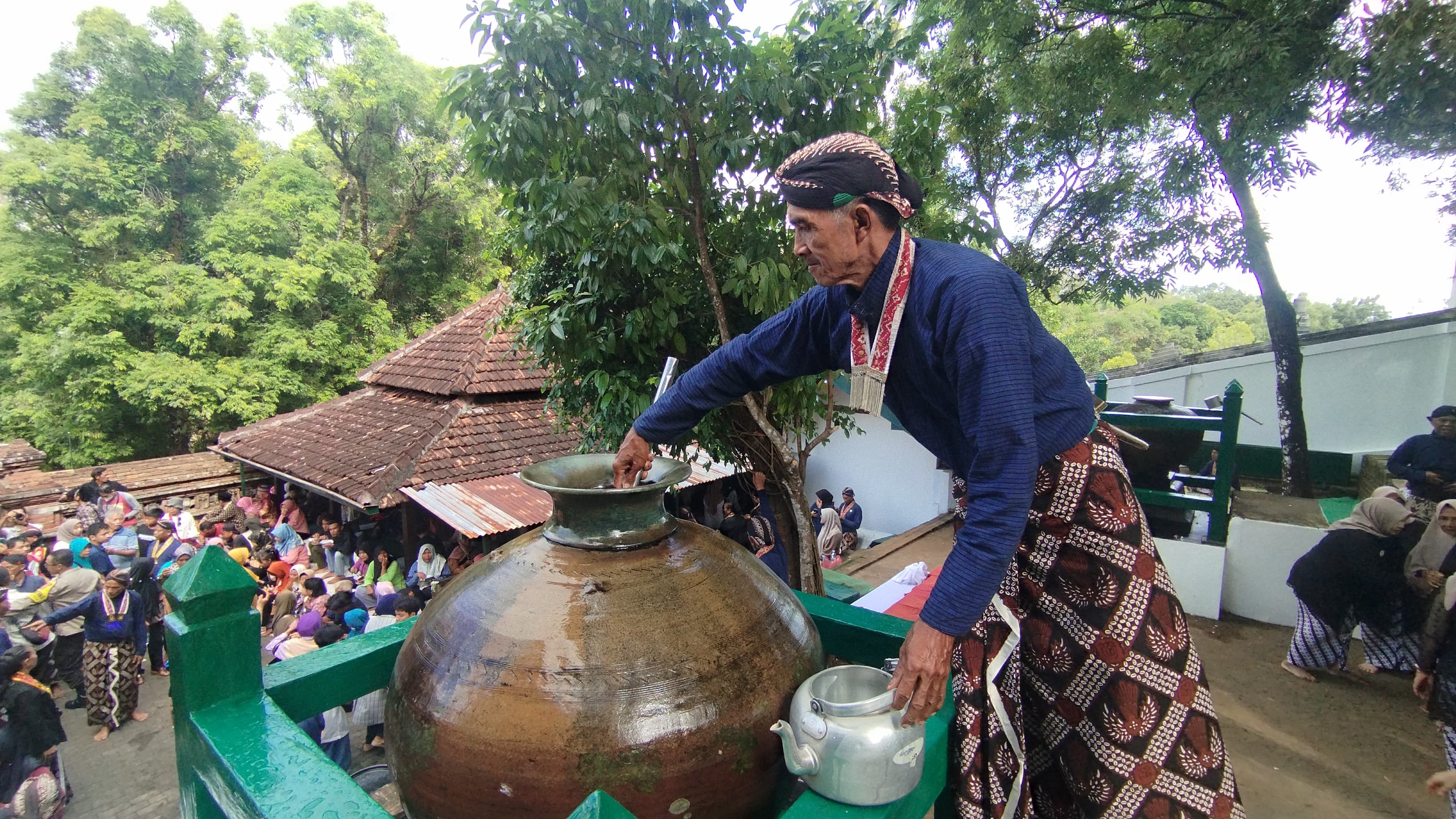 SAKRAL: Abdi Dalem Keraton Ngayogyakarta Hadiningrat sedang menuangkan air dari tempayan ke teko untuk dibagikan kepada warga pada Jumat (27/6)