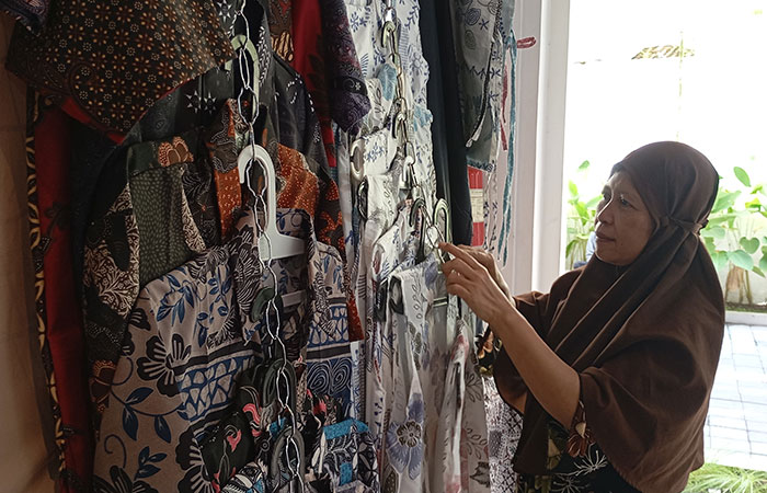 NESTAPA: Pedagang baju dan sandal khas Jogja di Teras Malioboro Ketandan Puji Astuti saat menata dagangannya kemarin (27/6). Momen libur panjang sekolah ini dagangannya sepi pembeli.
