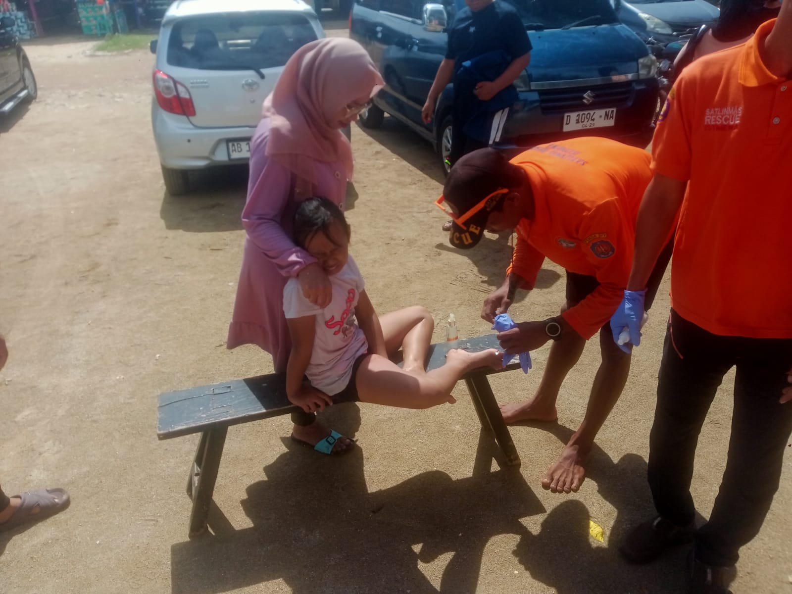 HARUS HATI-HATI: SRI Wilayah I Baron sedang melakukan penanganan pertama terhadap korban sengatan ubur-ubur di Pantai Kukup, kemarin (29/6).