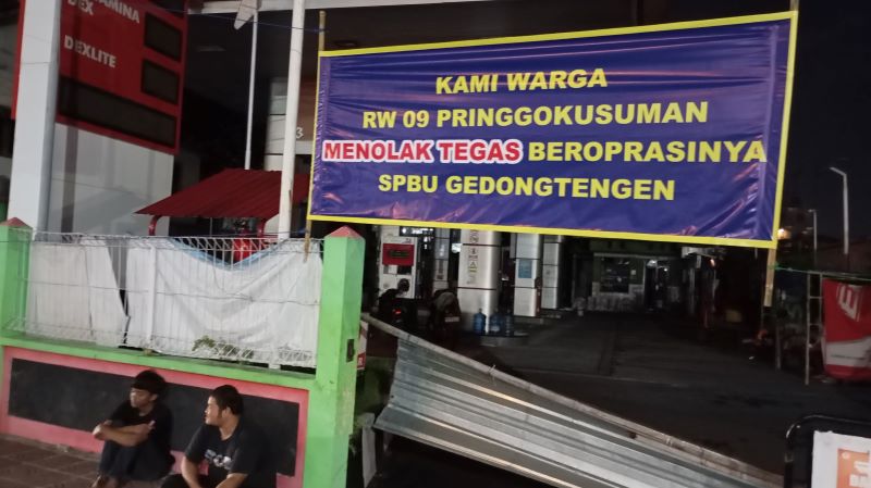 IMBAS LEDAKAN: Suasana SPBU Gedongtengen di Jalan Letjen Suprapto, Kota Jogja yang dipasang spanduk penolakan dari warga RW 09 Pringgokusuman Rabu (2/7) malam.