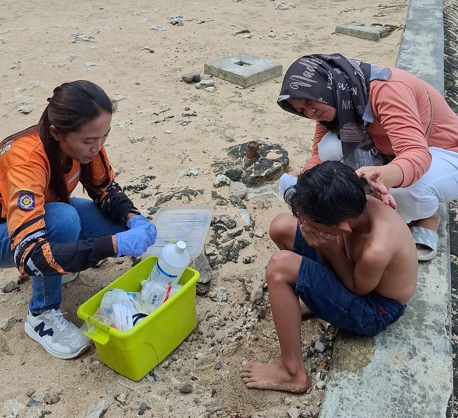 Petugas SRI Wilayah II Pantai Baron sedang melakukan penanganan pertama terhadap korban sengatan ubur-ubur pada Jumat (4/7).  &nbsp;