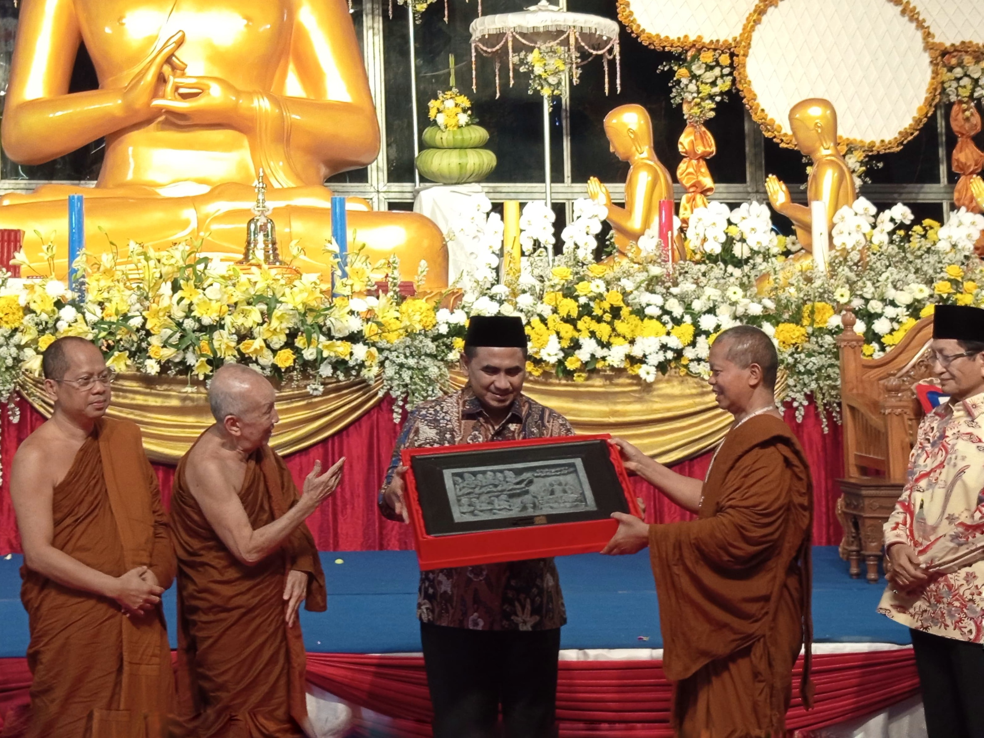 Perwakilan Sangha Theravada Indonesia saat memberikan kenang-kenangan kepada wakil gubernur Jateng saat puja bakti agung di Taman Lumbini, Candi Borobudur, Minggu (6/7).  &nbsp;