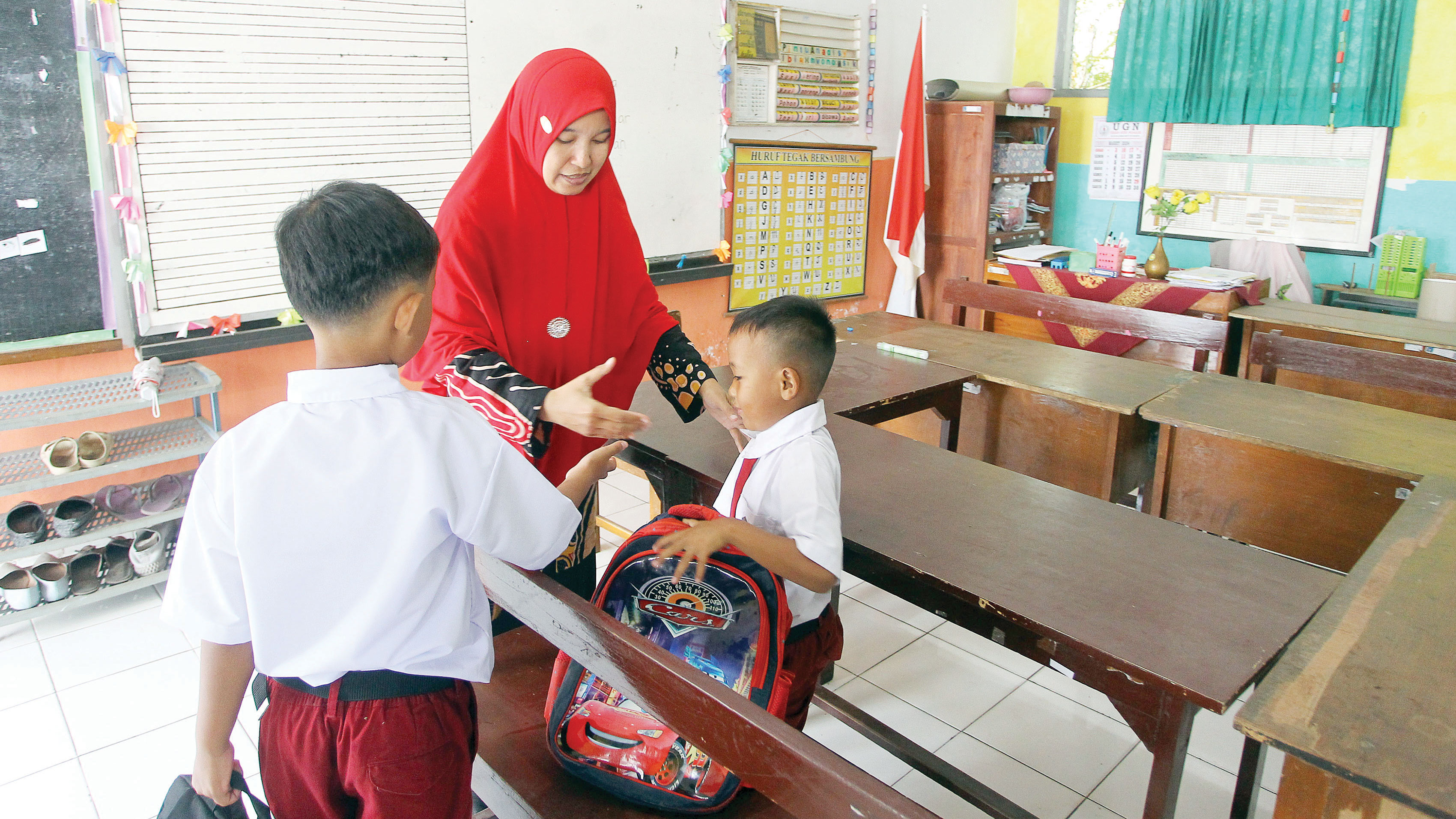 HARI PERTAMA: Guru memberikan pengarahan kepada dua siswa baru kelas 1 SDN Minomartani 2 saat berlangsung MPLS di Kapanewon Ngaglik, Sleman (14/7).