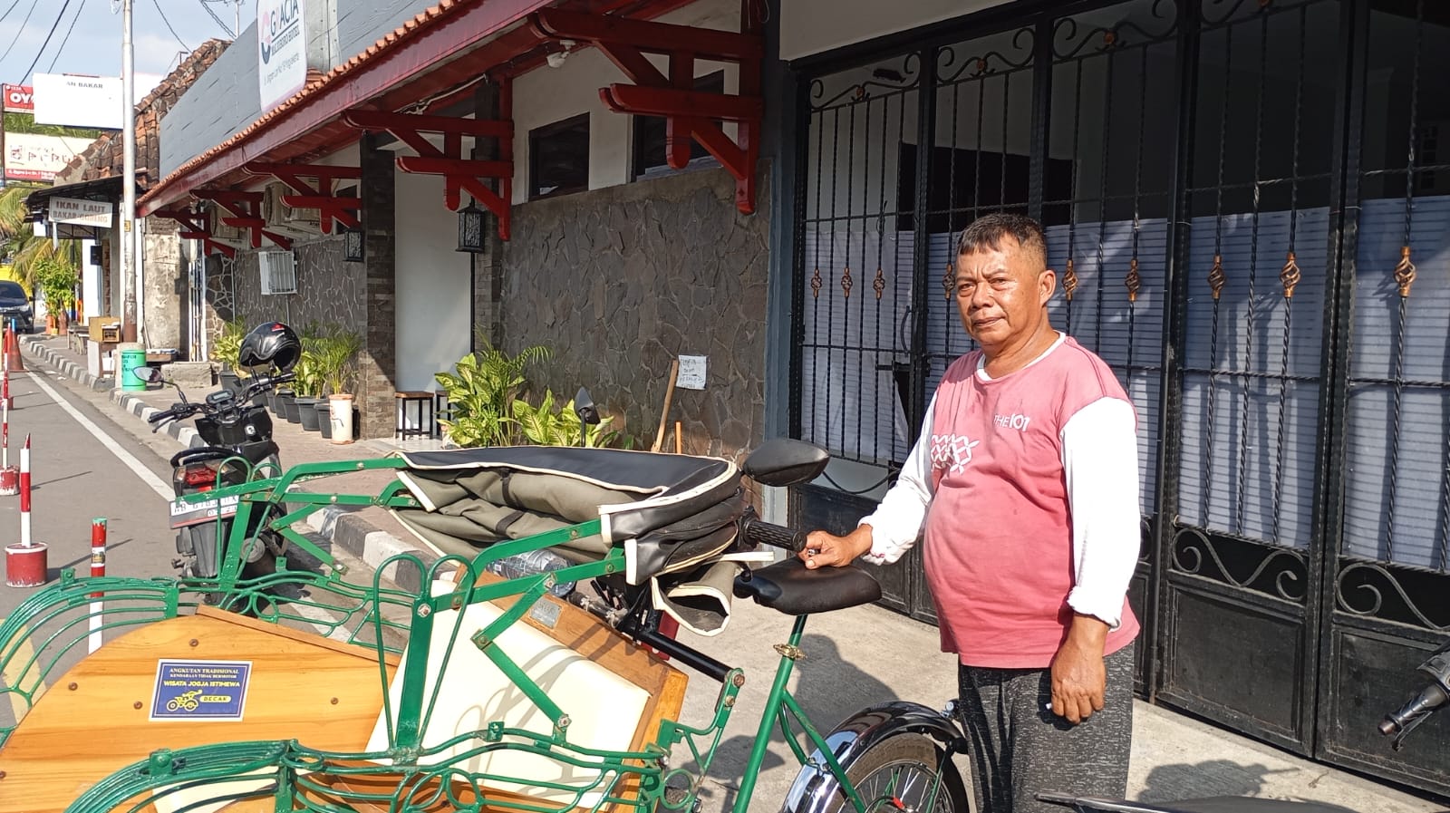 TUNGGU PENUMPANG: Salah seorang tukang becak listrik Dani Pramono saat mangkal di Jalan Pasar Kembang, Kota Jogja pada Jumat (18/7/2025).
