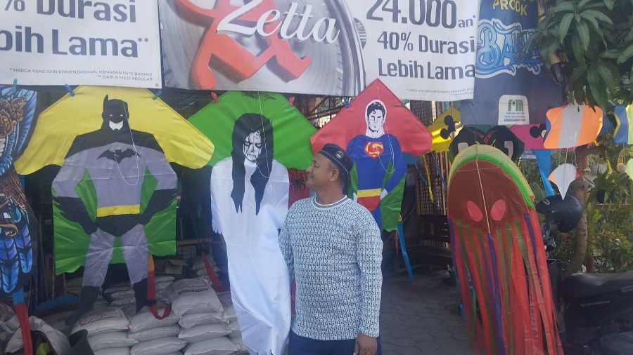 MENGAMATI: Sunardi sedang berada di depan tokonya sambil melihat layang-layang yang ia jual
