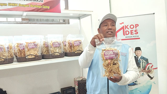 SIAP MELAYANI: Yeri Widarmanto sedang memperlihatkan salah satu sembako yang dijual di gerai KDMP Kalurahan Bangunharjo, Senin (21/7/2025).