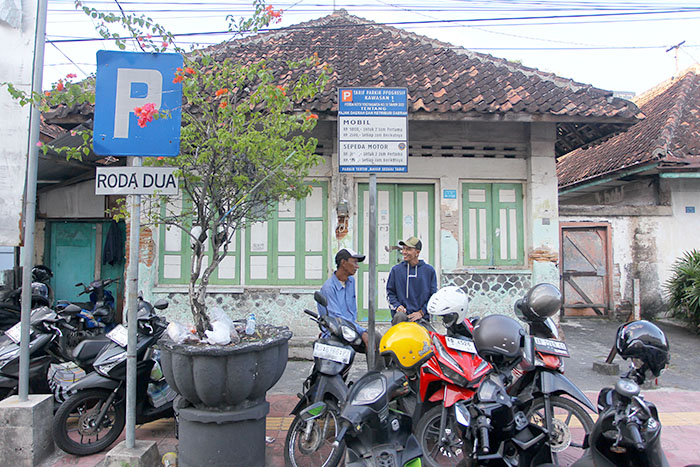 Juru parkir melayani pengendara sepeda motor yang memarkirkan kendaraan di kawasan parkir Jalan Prof. Yohanes, Kota Jogja, Senin (21/7/2025).