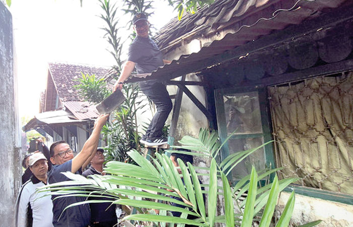 Partisipasi Swasta: Wali Kota Jogja Hasto Wardoyo menurunkan genting dan diterima Wakil Wali Kota Wawan Harmawan di salah satu rumah warga yang akan direhab dalam program bedah rumah.