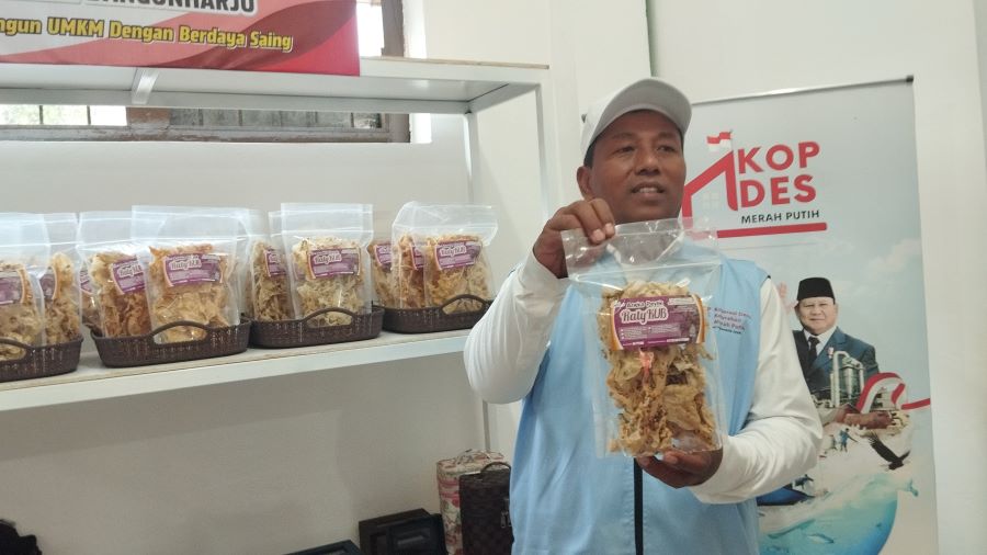 MEMAMERKAN: Yeri Widarmanto sedang memperlihatkan salah satu sembako yang dijual di gerai koperasi Merah putih Kalurahan Bangunharjo Senin (21/7)