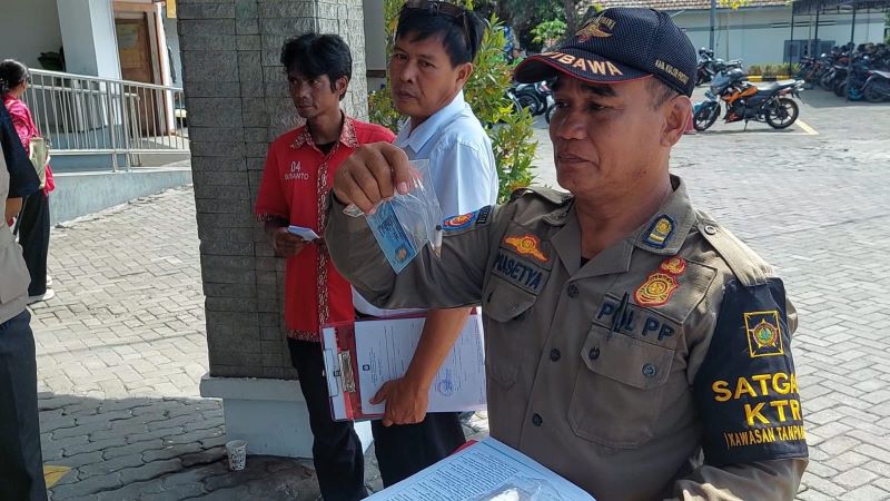 PENEGAKAN: Personel Satpol PP menunjukkan puntung rokok yang dibunga di area KTR.&nbsp;