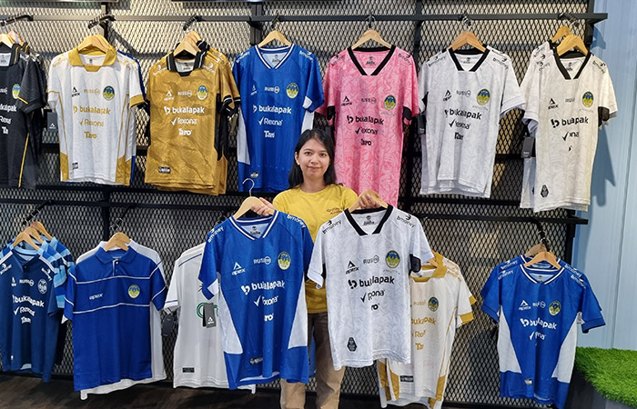 LARIS MANIS: Staf PSIM store menunjukkan koleksi jersey dan merchandise mereka.