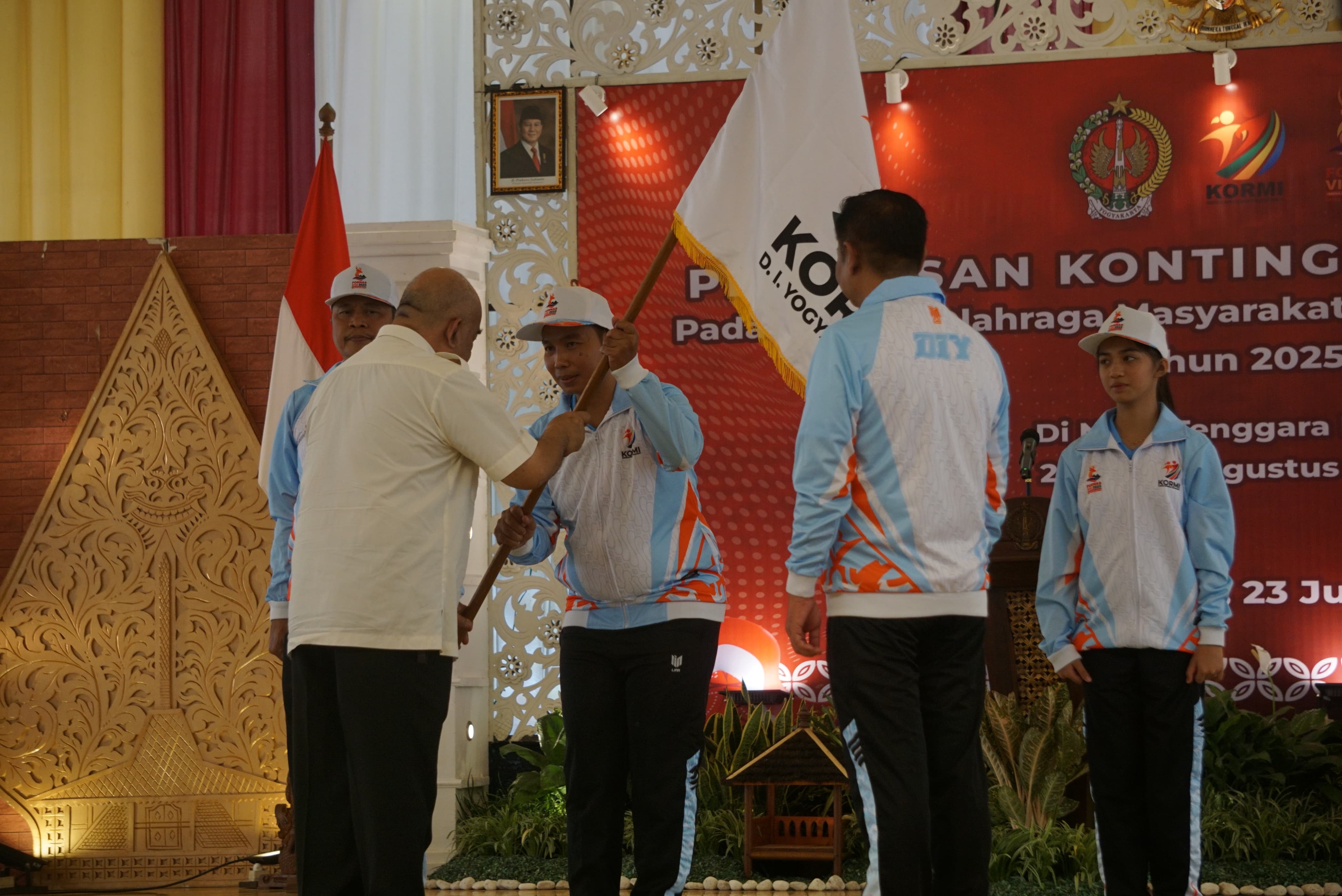 Ketua Kontingen KORMI DIJ yang akan tampil di Fornas VIII NTB 2025, Saryono saat menerima pataka kontingen KORMI DIJ dari Wagub DIJ KGPAA Paku Alam X saat pelepasan kontingen di Gedhong Pracimasana,