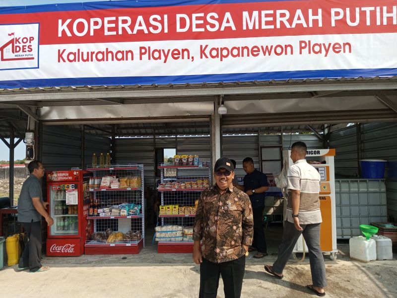 TELATEN: Suharno, lurah Playen yang juga pemilik pom minyak goreng saat melayani pembeli Jumat (25/7).