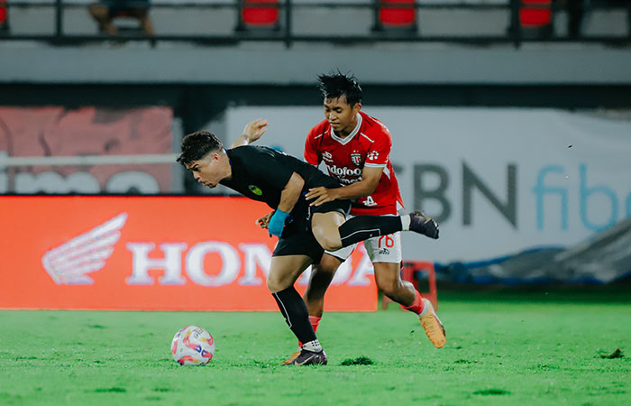 Pemain PSIM Jogja Rafinha mempertahankan bola dari pemain Bali United Kadek Lanang dalam laga uji coba yang digelar Sabtu (26/7/2025).