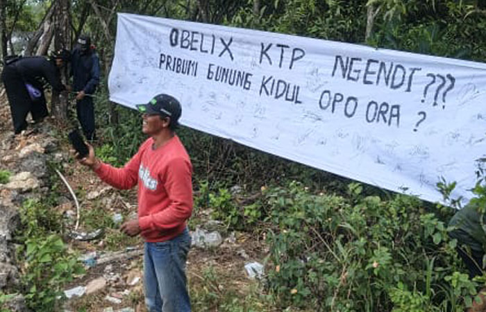 TAK GENTAR: Anggota Sanglen Berdaulat memasang poster protes di kawasan Pantai Sanglen,&nbsp;Senin&nbsp;(28/7/2025).