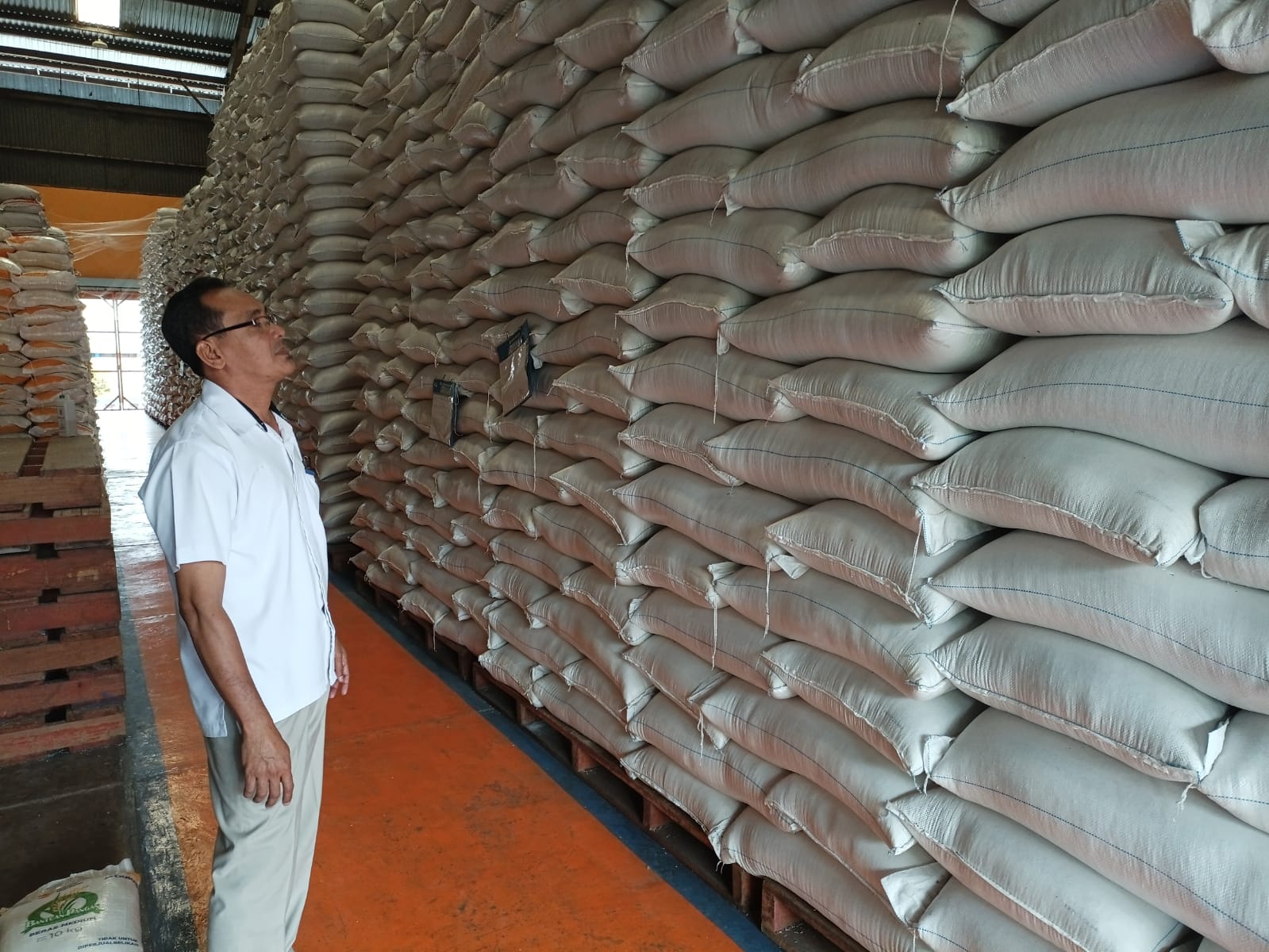 Kepala Gudang Bulog Kebumen Sidik Sugiharto mengecek tumpukan beras hasil program penyerapan gabah dari petani.   &nbsp;