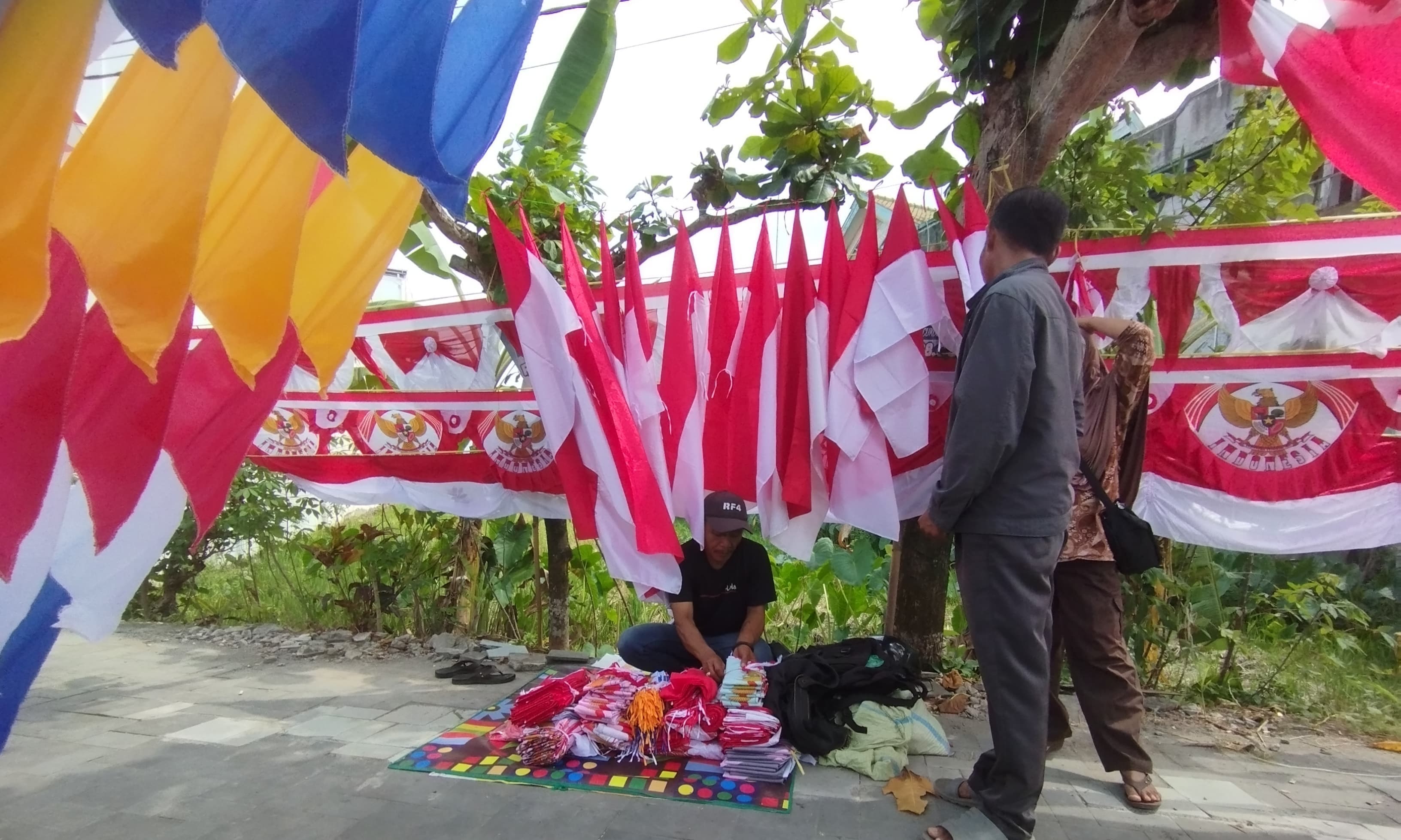 LARIS: Penjual bendera musiman di Kulon Progo sedang menata barang dagangannya, kemarin.