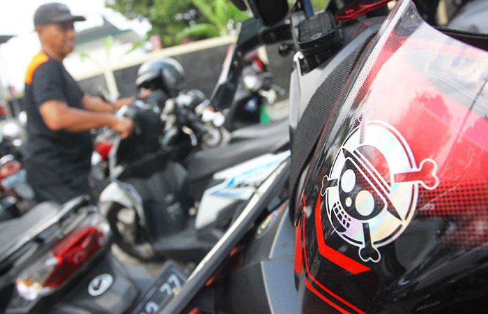 Stiker anime One Piece tertempel di helm salah satu pengendara sepeda motor yang terparkir di kawasan Giwangan, Kota Jogja, Selasa (5/8/2025).