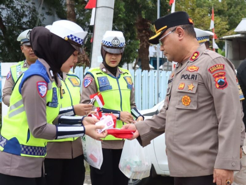 SEMARAK AGUSTUSAN : Kapolres Kebumen AKBP Eka Baasith Syamsuri memimpin pembagian bendera merah putih di kawasan Jalan Soekarno-Hatta.