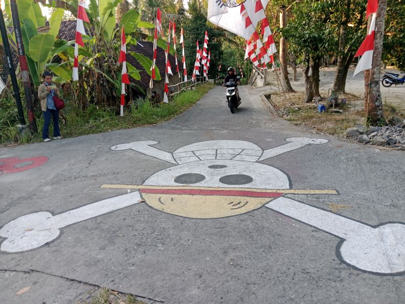 ADA DI JALAN:  Mural bergambar tengkorak bajak laut topi jerami dari anime One Piece di jalan persimpangan Balecatur, Gamping, Sleman