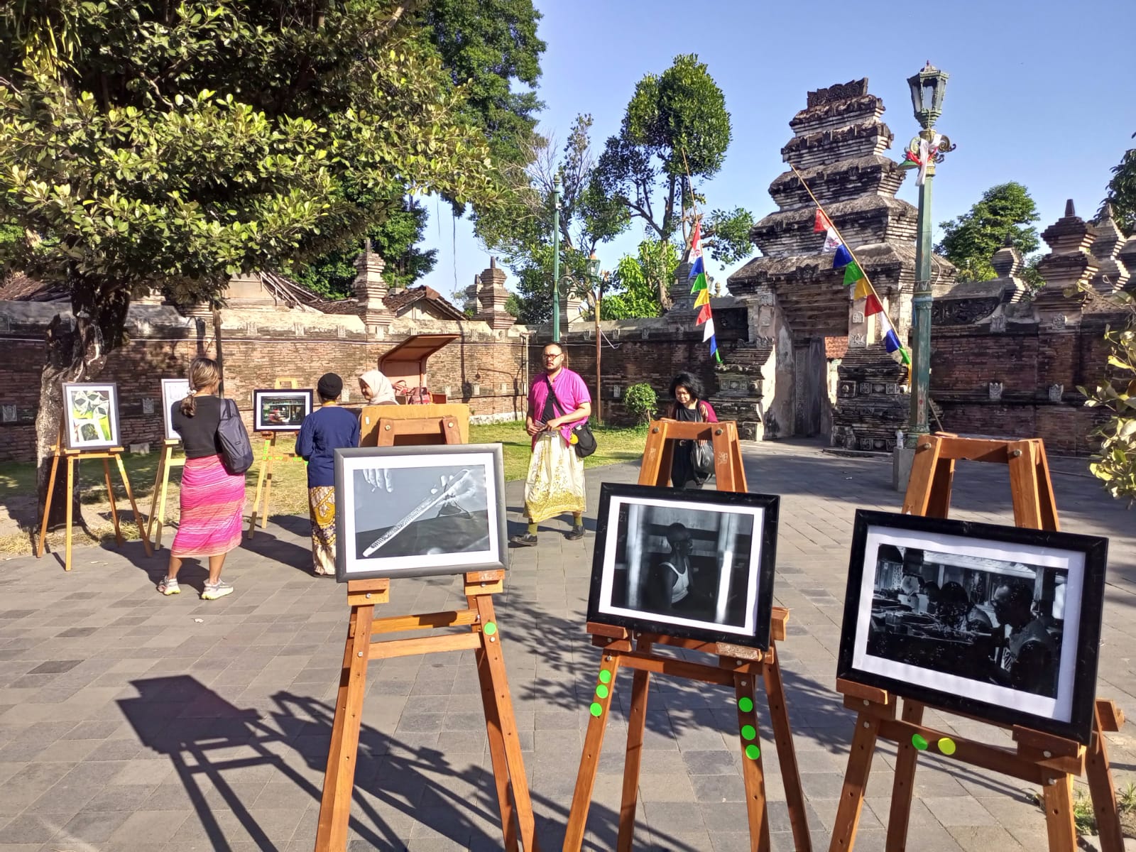 Pengunjung mengamati karya foto yang dipajang dalam pameran foto dokumenter bertajuk Heritage Charm Form Multicultural Lens di kompleks Masjid Gede Mataram, Kotagede, Rabu (6/8/2025).