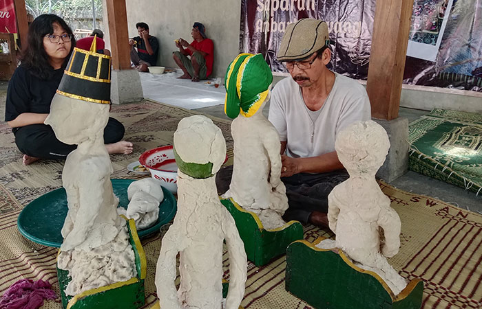 TRADISI: Sugiyantoro saat membuat boneka bekakak. Sepasang pengantin bekakak itu kemarin kemudian disembelih dalam upacara Saparan di Gamping.