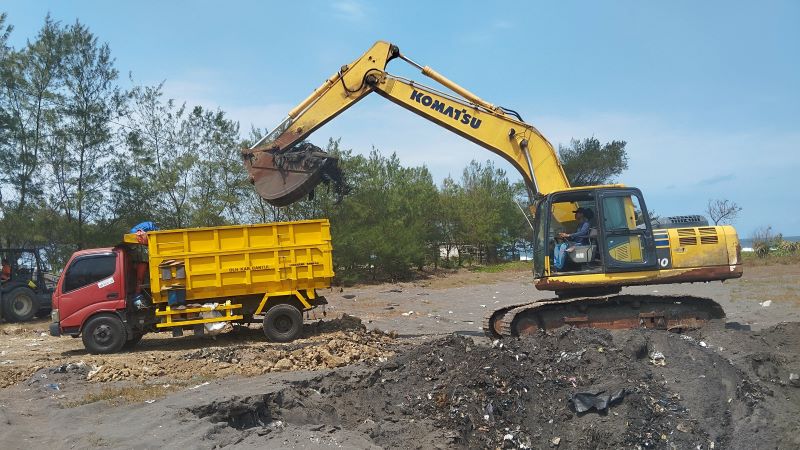 PROSES PEMINDAHAN: Sampah yang berada di TPSS Pandasari sedang dipindahkan ke dalam truk untuk diangkut ke TPST Modalan Senin (11/8).