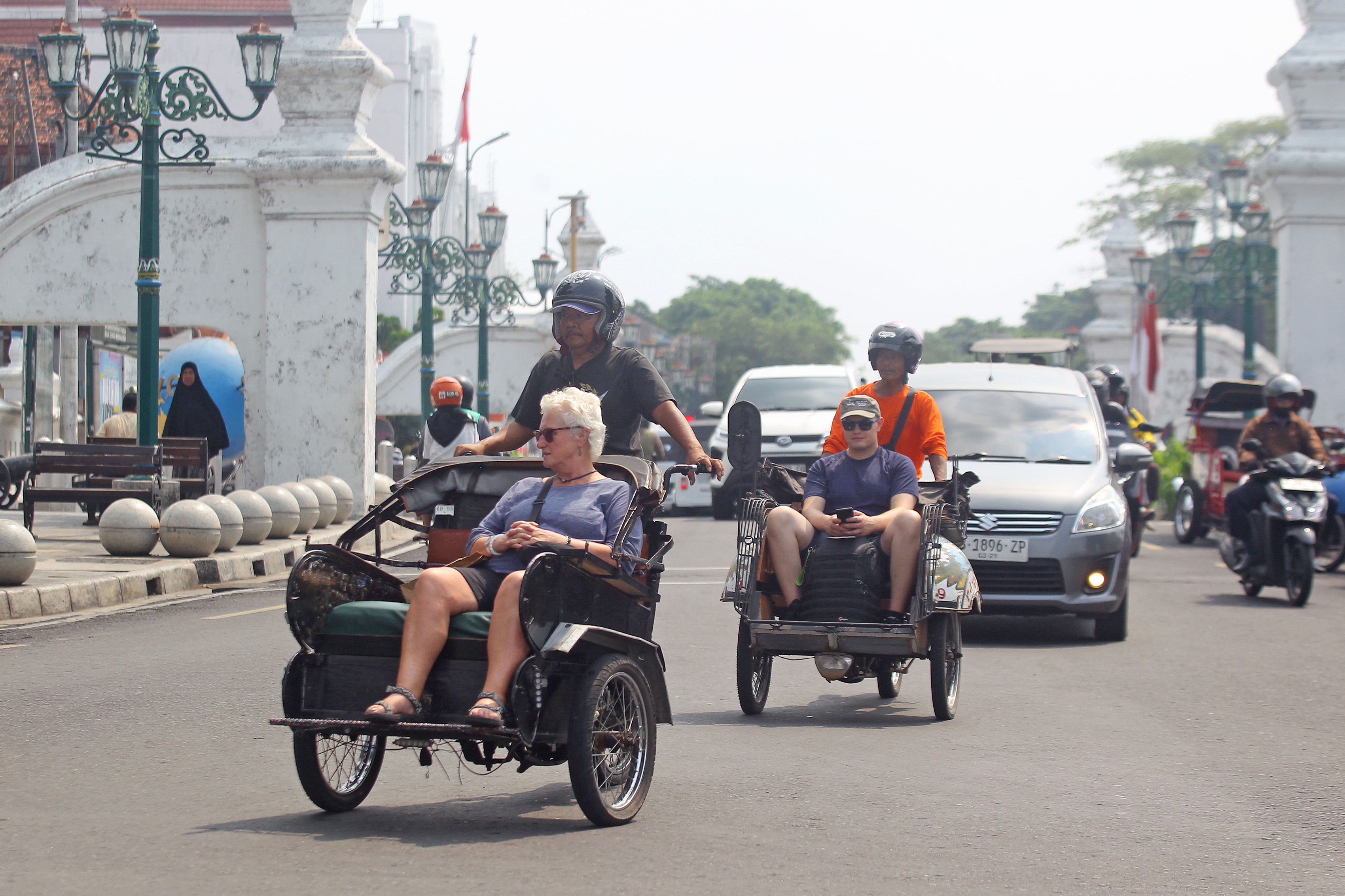 Wisatawan mancanegara berkeliling menggunakan becak motor saat melintas di kawasan Alun-alun Utara, Kota Jogja, kemarin (11/8).