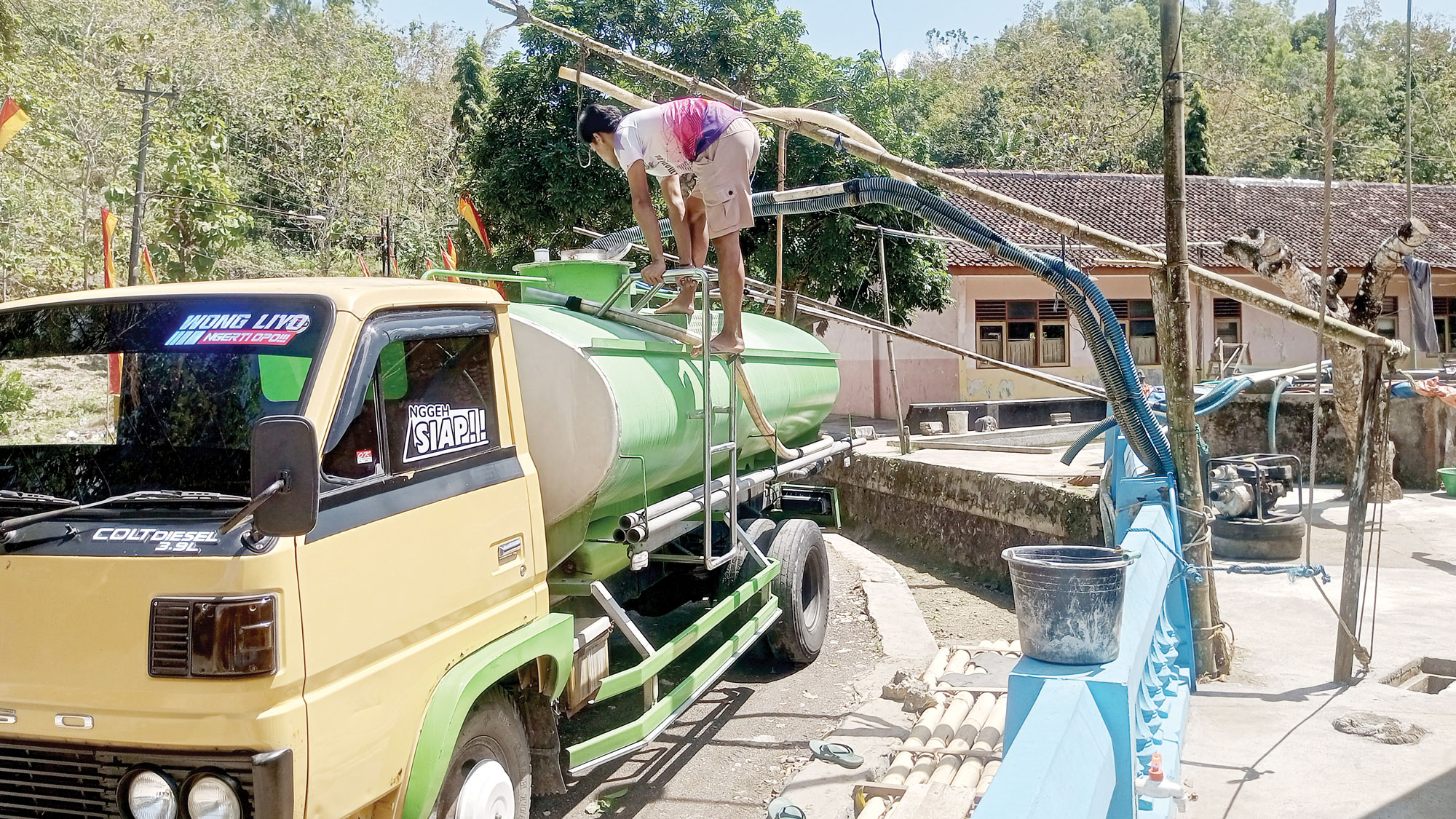 SEPI TAPI BERSYUKUR: Bramantyo, pengusaha droping air bersih sedang mengisi truk tangki miliknya yang berkapasitas 5.000 liter, kemarin (14/8).