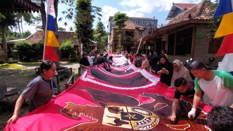 PELAPISAN: Pembatik mewarnai kain yang sebelumnya telah digambar sosok presiden.&nbsp;