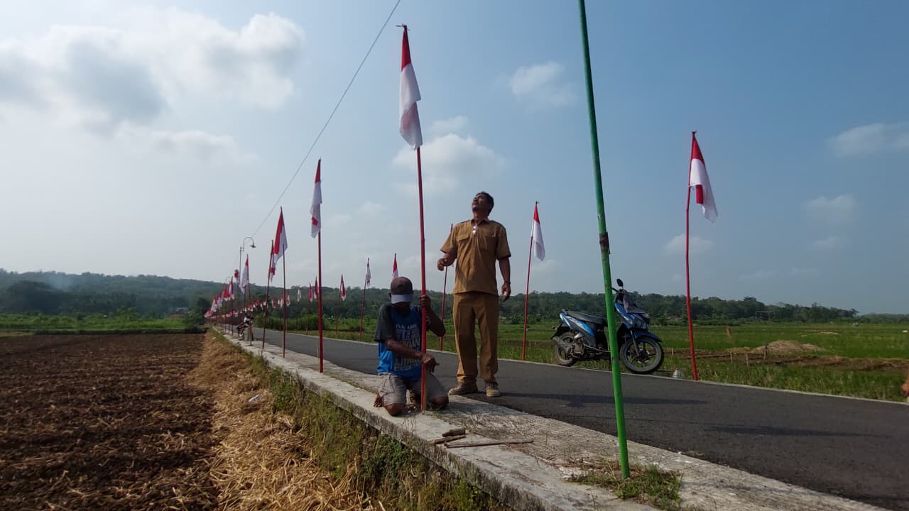 UNIK: Bendera Merah Putih membelah area sawah menuju pemukiman warga.&nbsp;
