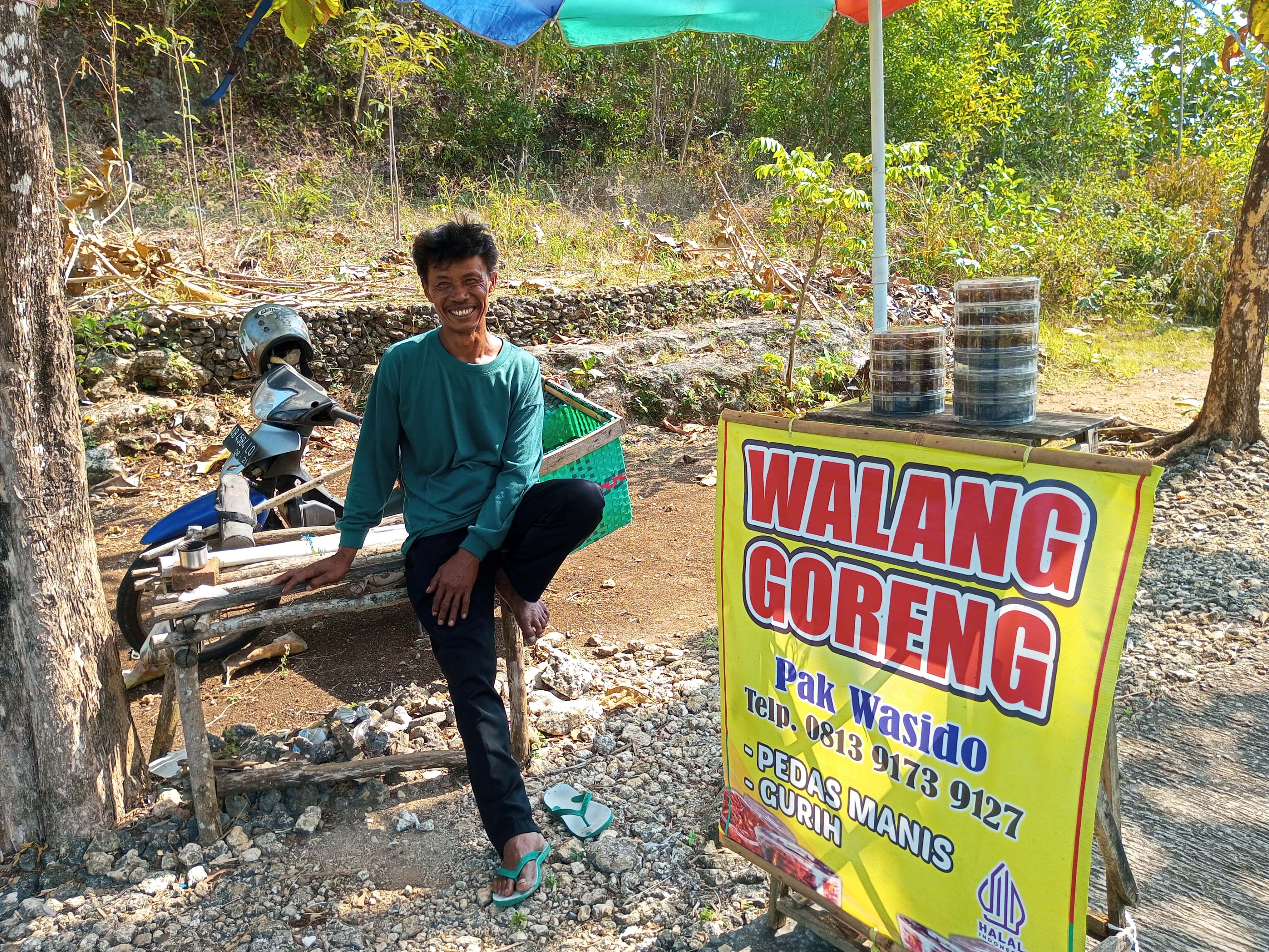 Wasido sedang menunggu para wisatawan mampir ke lapak walang goreng miliknya yang terletak di dalam kawasan wisata Baron pada Minggu (17/8).