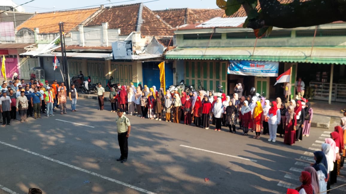 KHIDMAT: Warga Pasar Wates mengikuti upacara bendera di pelataran pasar.