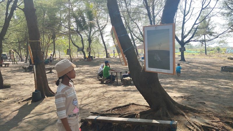 TERPUKAU: Pengunjung sedang melihat pameran foto di Pantai Cangkring, Poncosari, Srandakan, Bantul Senin (18/8)  