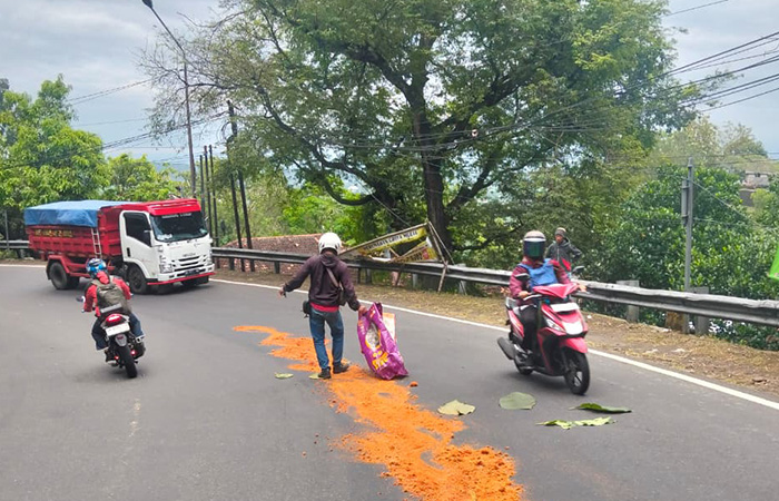 ANTISIPASI LAKA: Relawan menutup ceceran solar di jalan raya patuk menggunakan serbuk kayu, Senin siang (18/8).
